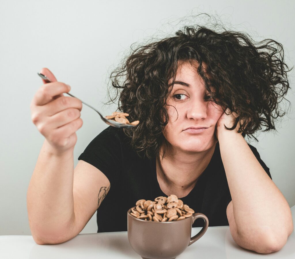 Unenthused woman unsure what to eat when hungry because nothing sounds good